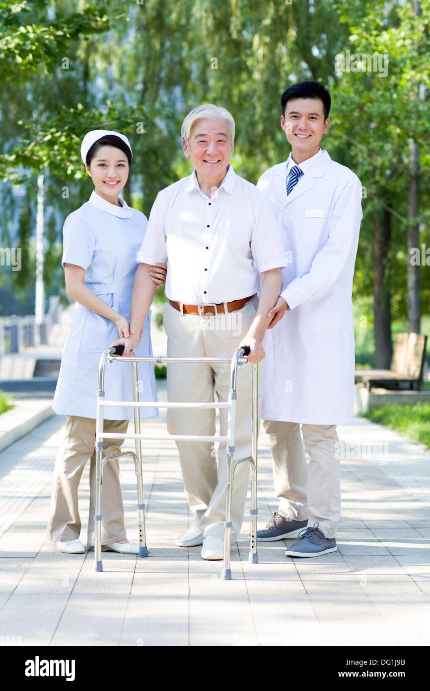 Man Walking avec déambulateur sous l'assistance de l'infirmière et médecin Banque D'Images