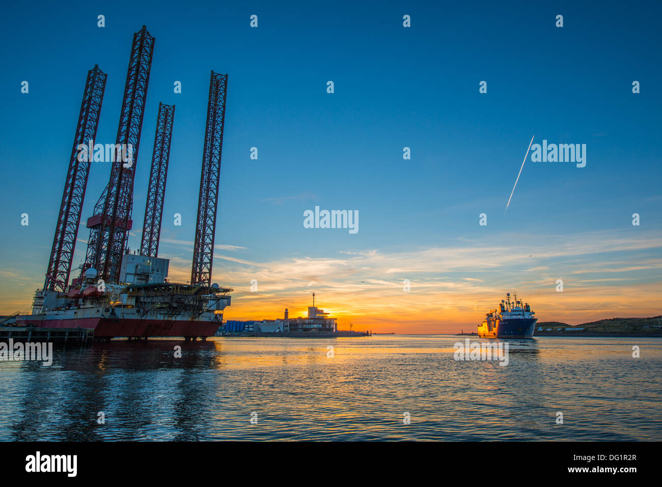 Derrick et navire en mer pendant le coucher du soleil dans le port de IJmuiden Banque D'Images