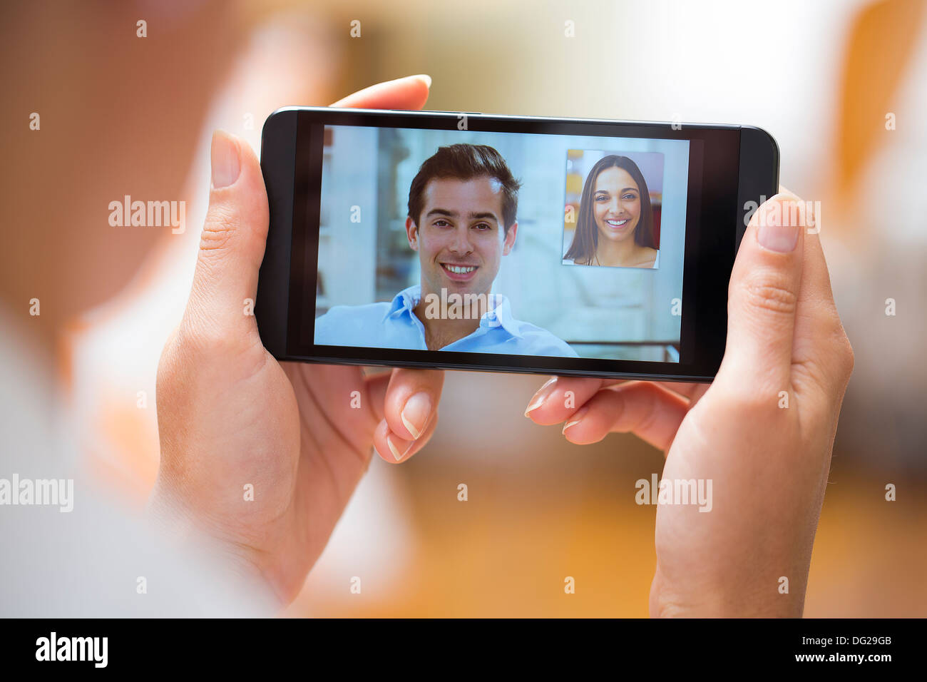 Femme de discuter avec son amie sur le smartphone à la maison Banque D'Images