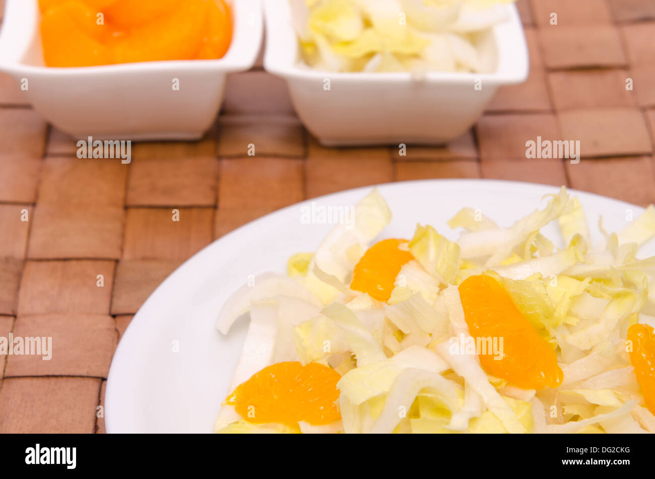 Avec salade de chicorée et des mandarines sur une plaque blanche Banque D'Images