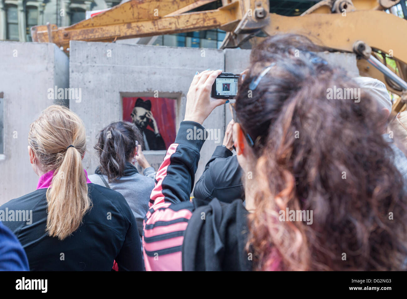 New York, USA. 12 octobre, 2013. Les amateurs d'art de rue troupeau à l'est Village près de New York le samedi 12 octobre, 2013 pour voir la douzième tranche de l'art graffiti de Banksy, 'confessionnal béton'. L'insaisissable artiste de rue, c'est la création d'œuvres autour de la ville chaque jour durant le mois d'octobre, accompagnée d'un message enregistré, vous pouvez entendre en appelant le numéro 1-800-656-4271 suivi de #  et le nombre d'œuvres. Crédit : Richard Levine/Alamy Live News Banque D'Images