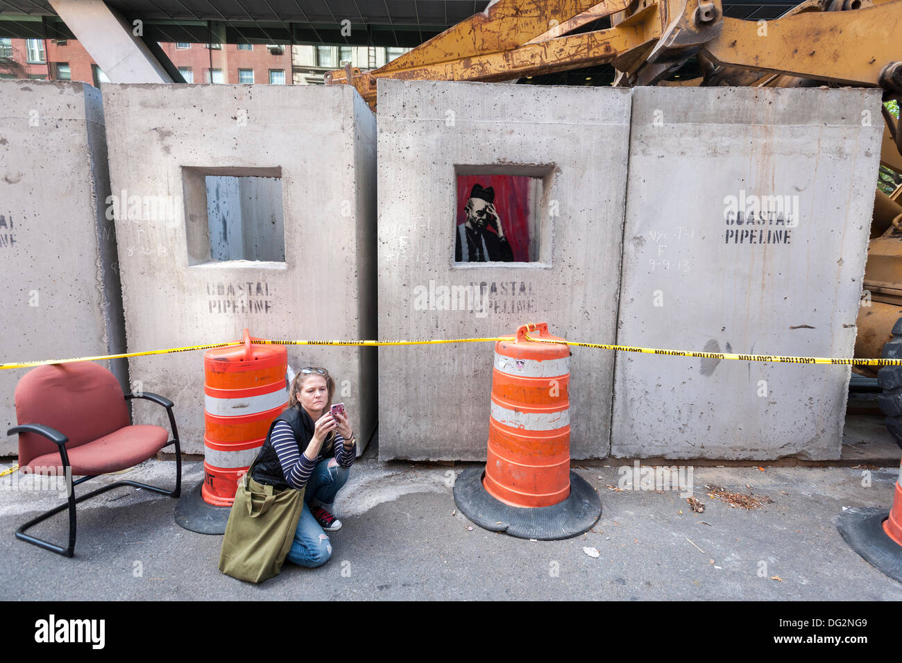 New York, USA. 12 octobre, 2013. Les amateurs d'art de rue troupeau à l'est Village près de New York le samedi 12 octobre, 2013 pour voir la douzième tranche de l'art graffiti de Banksy, 'confessionnal béton'. L'insaisissable artiste de rue, c'est la création d'œuvres autour de la ville chaque jour durant le mois d'octobre, accompagnée d'un message enregistré, vous pouvez entendre en appelant le numéro 1-800-656-4271 suivi de #  et le nombre d'œuvres. Crédit : Richard Levine/Alamy Live News Banque D'Images