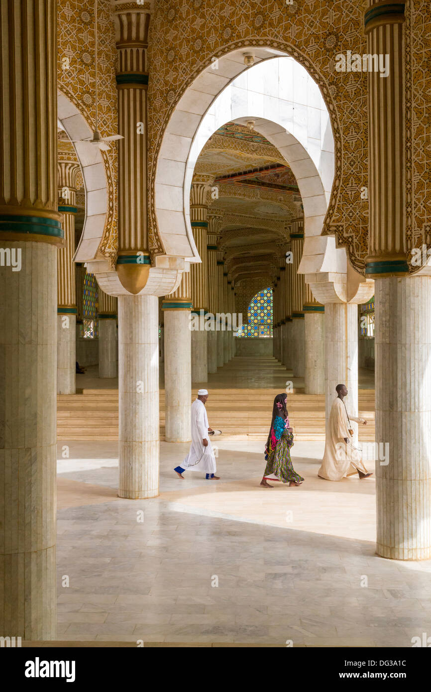 Sénégal, Touba. Trois fidèles quitter la Grande Mosquée--deux hommes et une femme. Banque D'Images