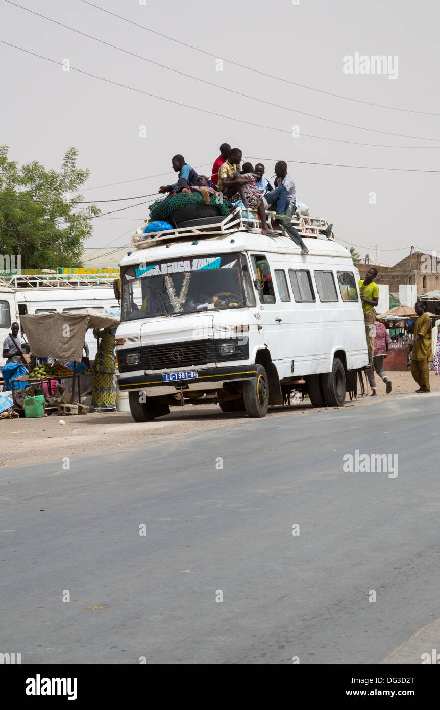 Sénégal, Touba. Transport local et la sécurité routière. Des jeunes hommes vont monter sur le dessus de la destination. Banque D'Images