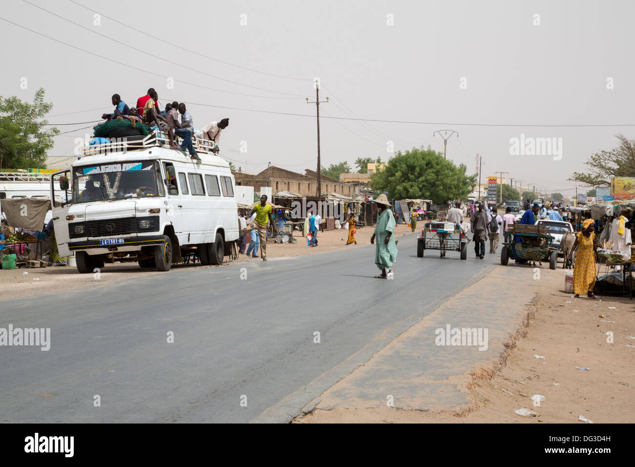 Sénégal, Touba. Transport local et la sécurité routière. Des jeunes hommes vont monter sur le dessus de la destination. Banque D'Images