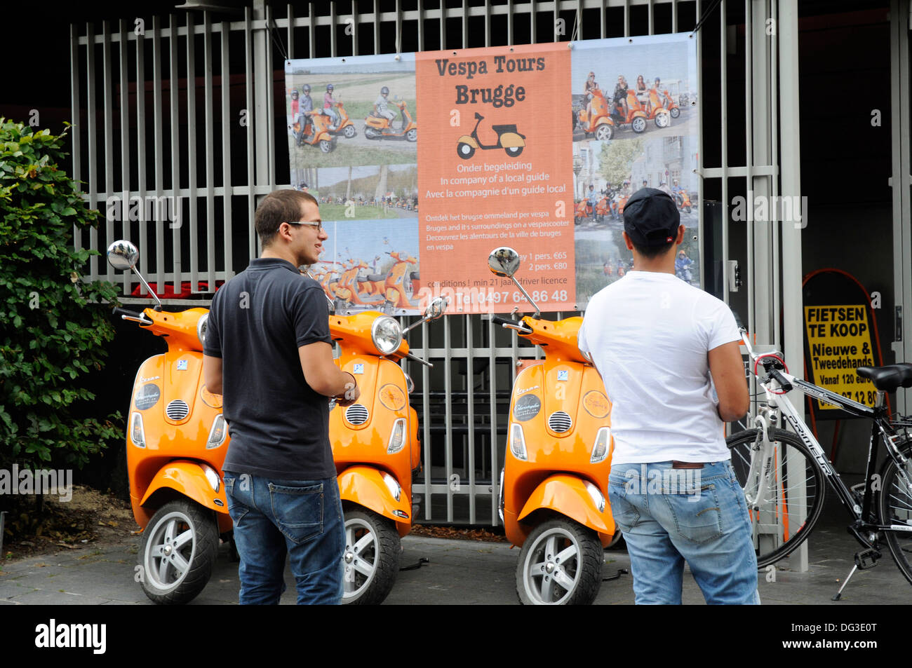 Deux jeunes hommes à Bruges Belgique à la ville de tours sur un scooter Vespa Banque D'Images