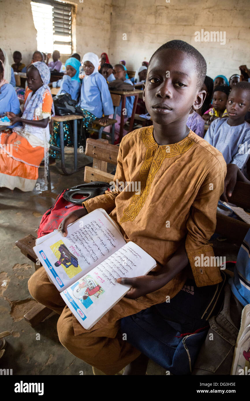 Sénégal, Touba. Jeune garçon avec son lecteur arabe Madrasa Al-Azhar, une école pour les études islamiques. Banque D'Images