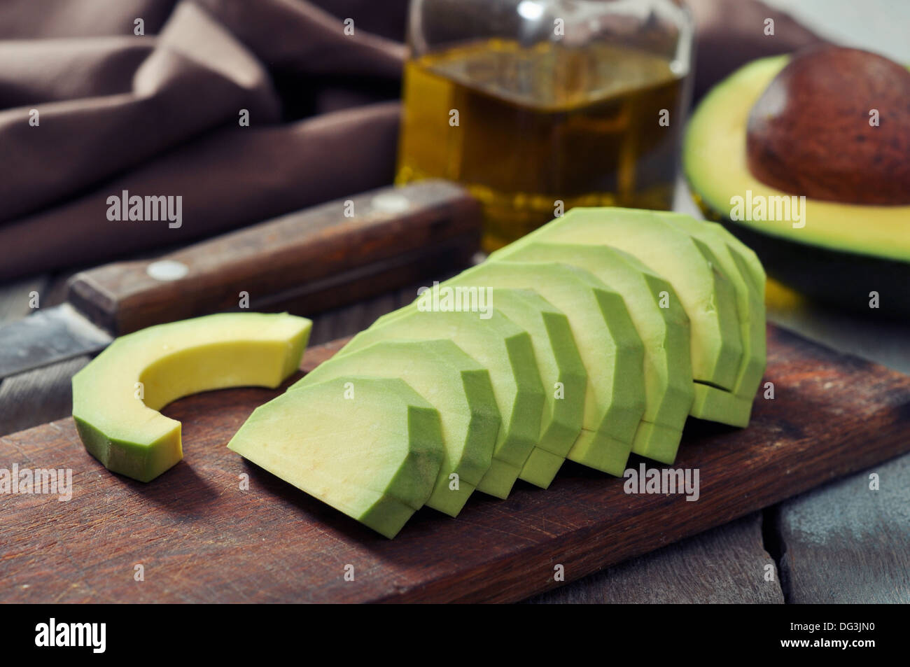 Les tranches d'avocat sur une planche à découper sur fond de bois Banque D'Images