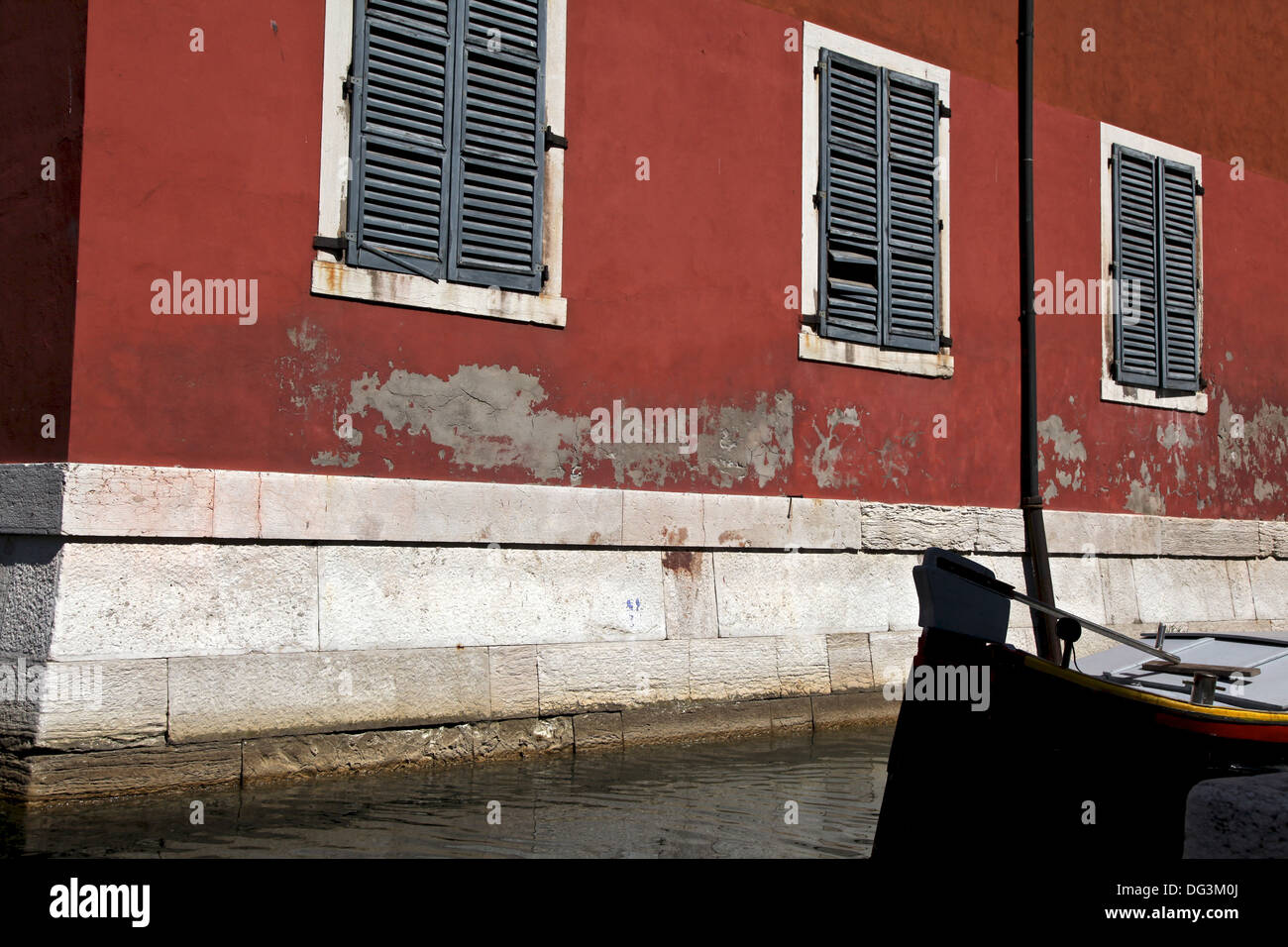 Un beau mur rouge en terre cuite avec la peinture pèle du dans un canal à Venise Banque D'Images