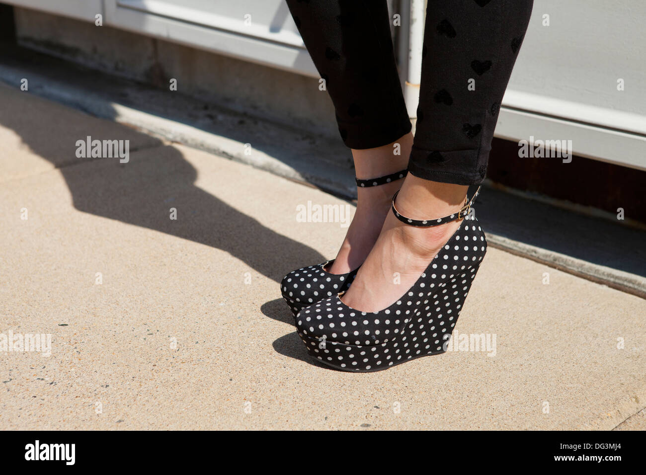 Femme vêtu de noir et blanc à pois à talons de plate-forme - USA Banque D'Images