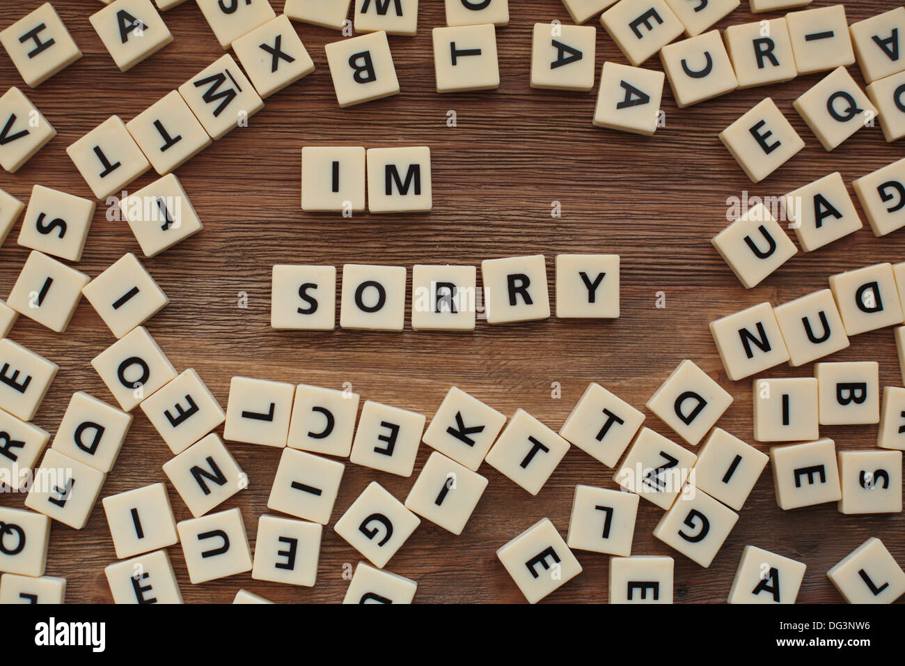 Lettres en plastique à partir d'une orthographe pour enfants jeu sur une table de bois sort 'Je suis désolé' Banque D'Images