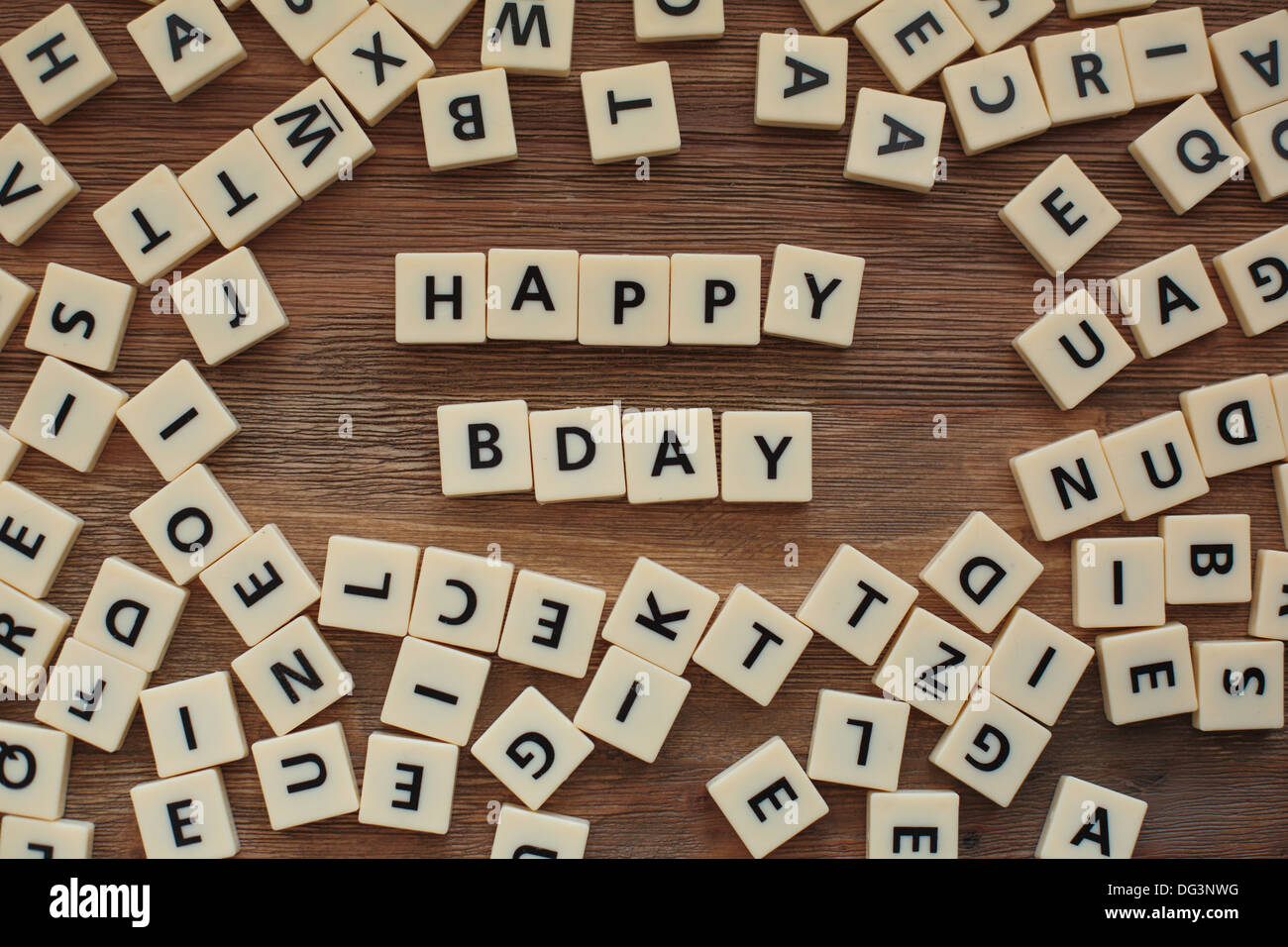 Lettres en plastique à partir d'une orthographe pour enfants jeu sur une table de bois sort 'Happy Bday" Banque D'Images