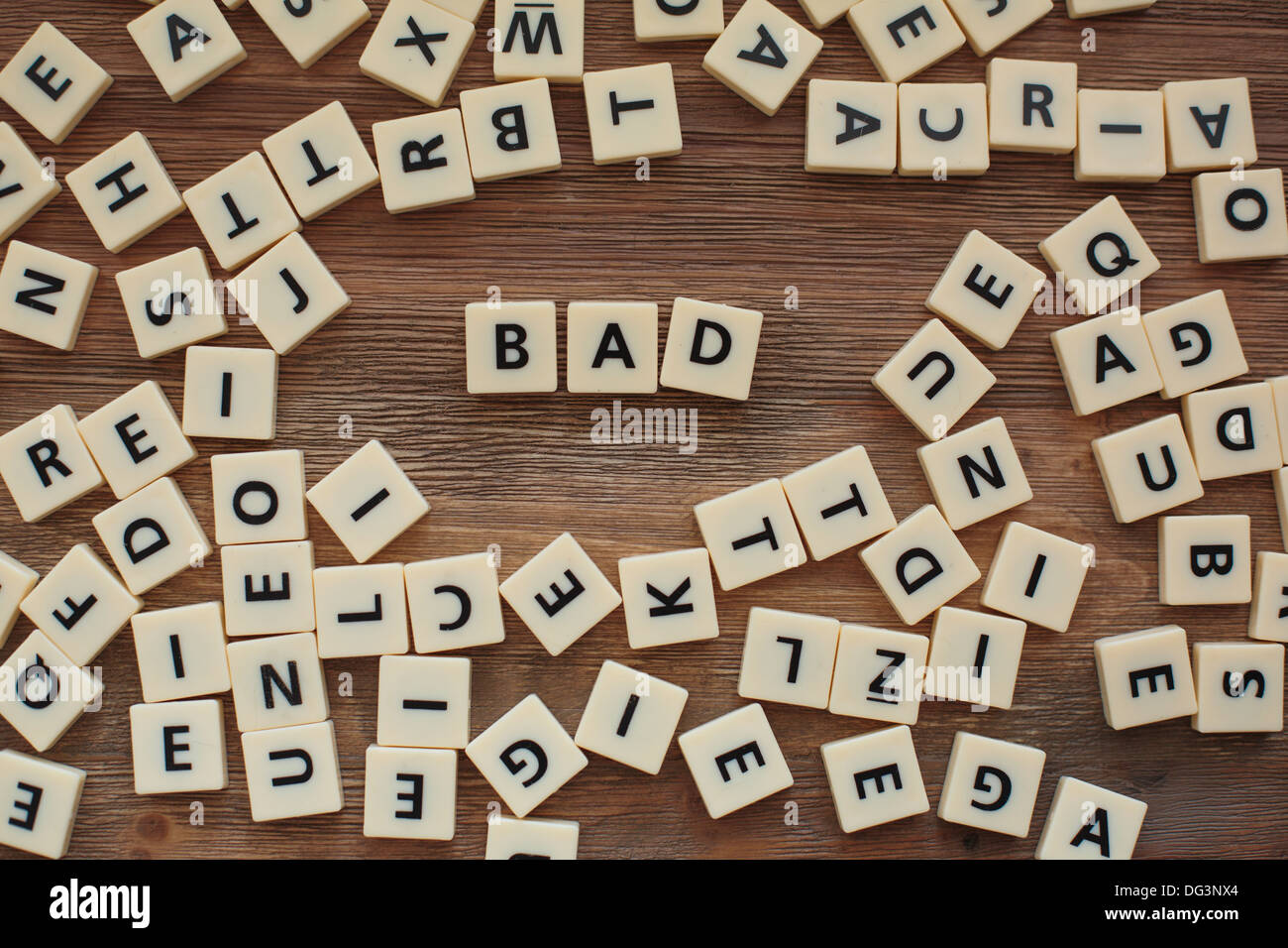Lettres en plastique à partir d'une orthographe pour enfants jeu sur une table en bois épeler le mot "mauvaise" Banque D'Images