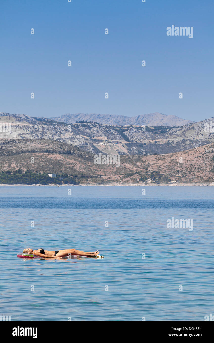 Une femme le bain de soleil sur un lilo, Dubrovnik, Dalmatie, Croatie, Europe Banque D'Images