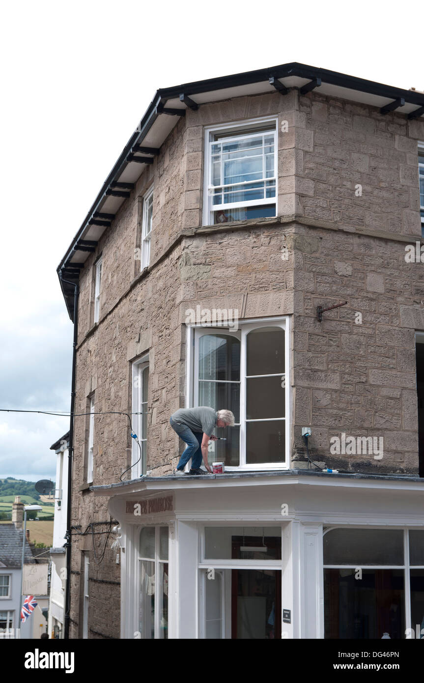 Hay-on-Wye dame mature une peinture blanche boutique en Powys Pays de Galles Banque D'Images