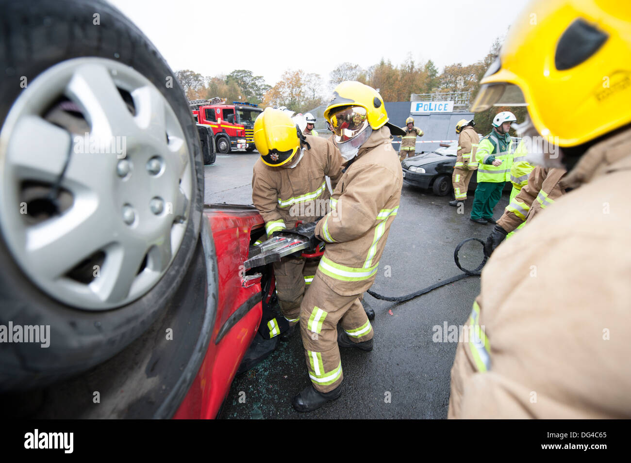 Les pompiers porte coupe off voiture renversée Banque D'Images