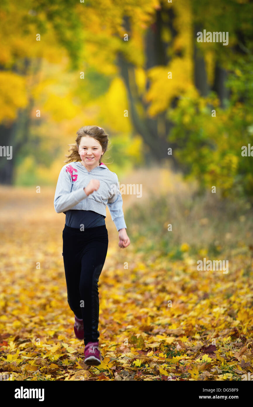 Jeune fille courir dans le parc Banque D'Images