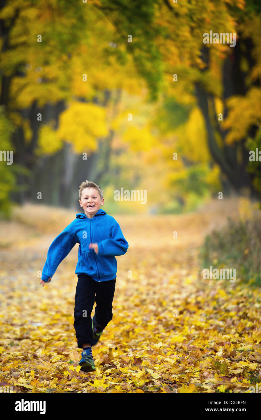 Jeune garçon courir dans le parc Banque D'Images