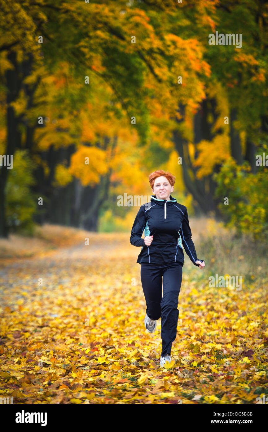 Jeune femme courir dans le parc Banque D'Images