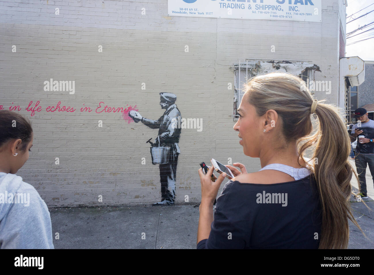 New York, USA. 14Th Oct, 2013. Les amateurs de street art affluent au voisinage de Woodside Queens à New York le lundi 14 octobre, 2013 pour voir la quatorzième tranche de l'art graffiti de Banksy, 'ce que nous faisons dans la vie résonne dans l'éternité". L'insaisissable artiste de rue, c'est la création d'œuvres autour de la ville chaque jour durant le mois d'octobre, accompagnée d'un message enregistré, vous pouvez entendre en appelant le numéro 1-800-656-4271 suivi de #  et le nombre d'œuvres. (© Richard B. Levine) Crédit : Richard Levine/Alamy Live News Banque D'Images