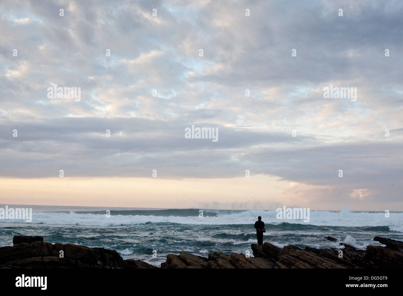 Un homme vues les vagues le long de la côte de l'Algarve au Portugal, Europe Banque D'Images