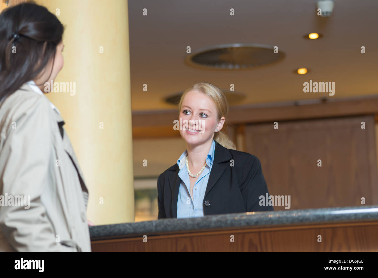 Jeune femme réceptionniste au bureau de l'hôtel Banque D'Images