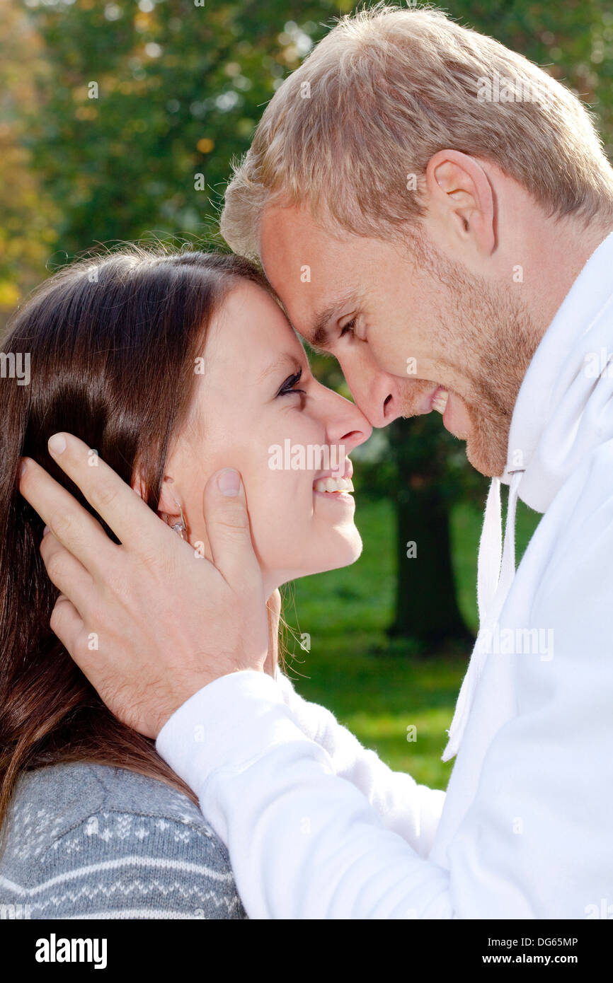 Portrait d'un jeune couple sympathique dans le parc, enlacés, souriant. Banque D'Images