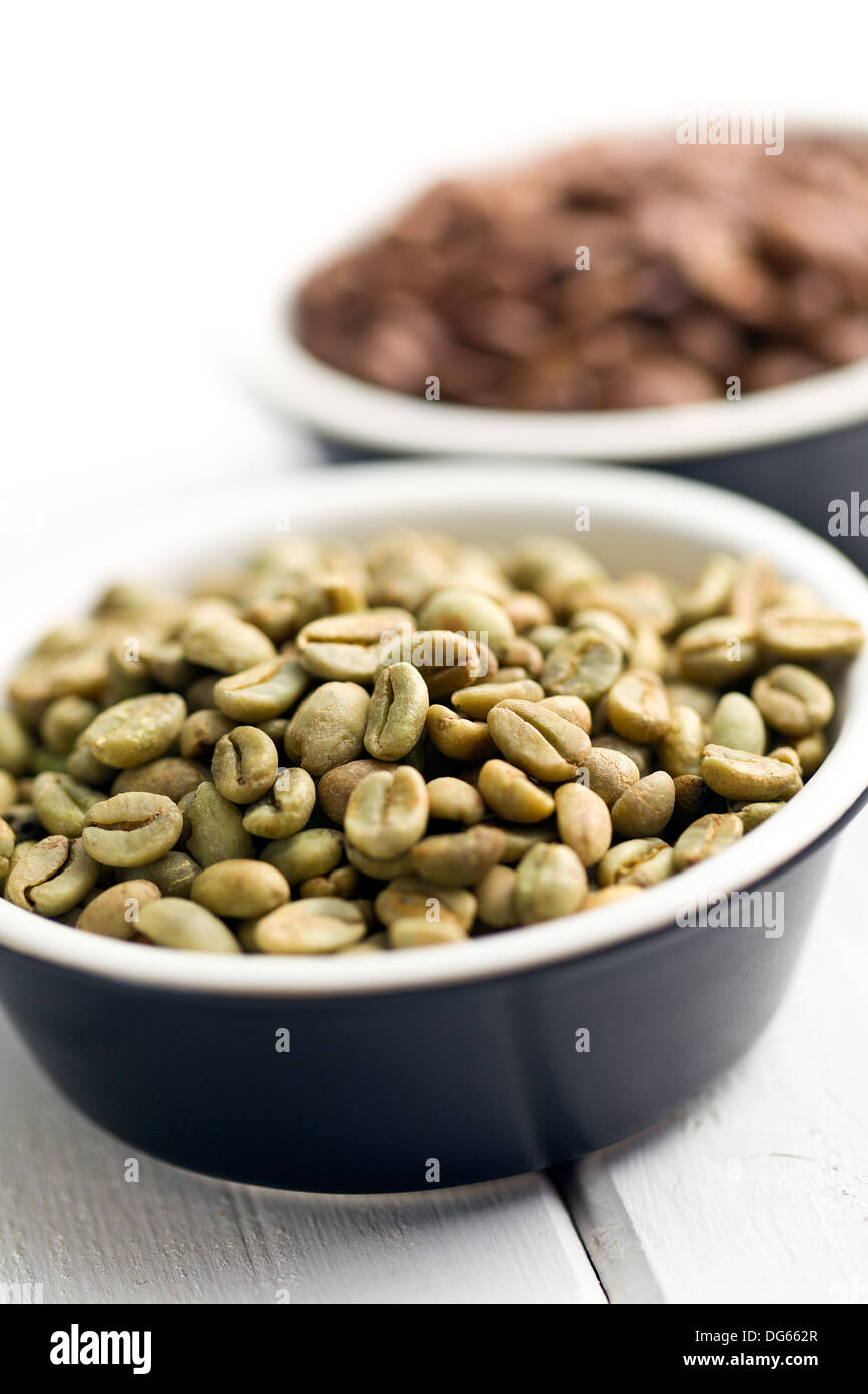 Les grains de café vert non torréfié dans Bol en céramique Banque D'Images