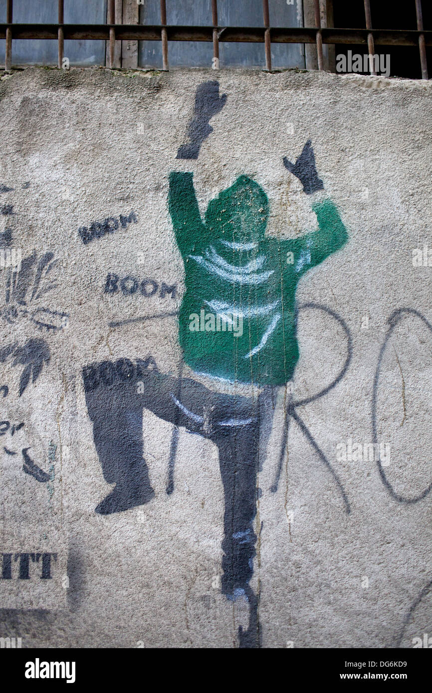 Graffiti sur un mur de ciment. Pochoir d'un homme grimpant sur un mur. Banque D'Images