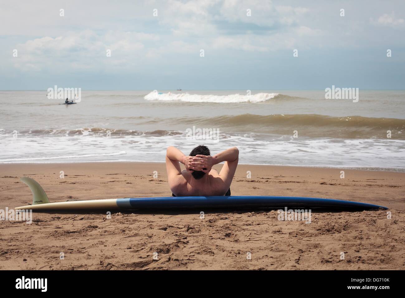 Mar del Plata, Buenos Aires, Argentine. 15 Oct, 2013. Un homme se penche sur son surf se détend comme sur la plage. Le printemps a commencé dans l'hémisphère sud et les surfeurs et les familles sont à apprécier le soleil et le temps chaud. © Ryan Noble/ZUMAPRESS.com/Alamy Live News Banque D'Images