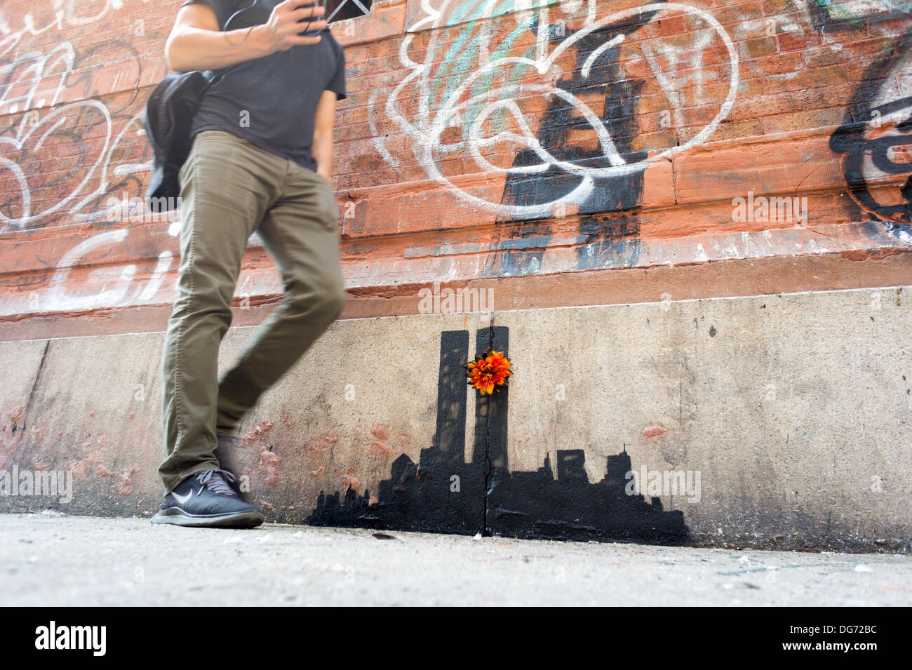 New York, USA. 15 octobre 2013. Les amateurs de street art affluent au quartier de Tribeca de New York le mardi, Octobre 15, 2013 à voir la quinzième tranche de graffiti de Banksy, l'art, 'Tribecca'. L'insaisissable artiste de rue, c'est la création d'œuvres autour de la ville chaque jour pendant le mois d'octobre et cette tranche montre une silhouette du World Trade Center avec une fleur en annexe. Crédit : Richard Levine/Alamy Live News Banque D'Images