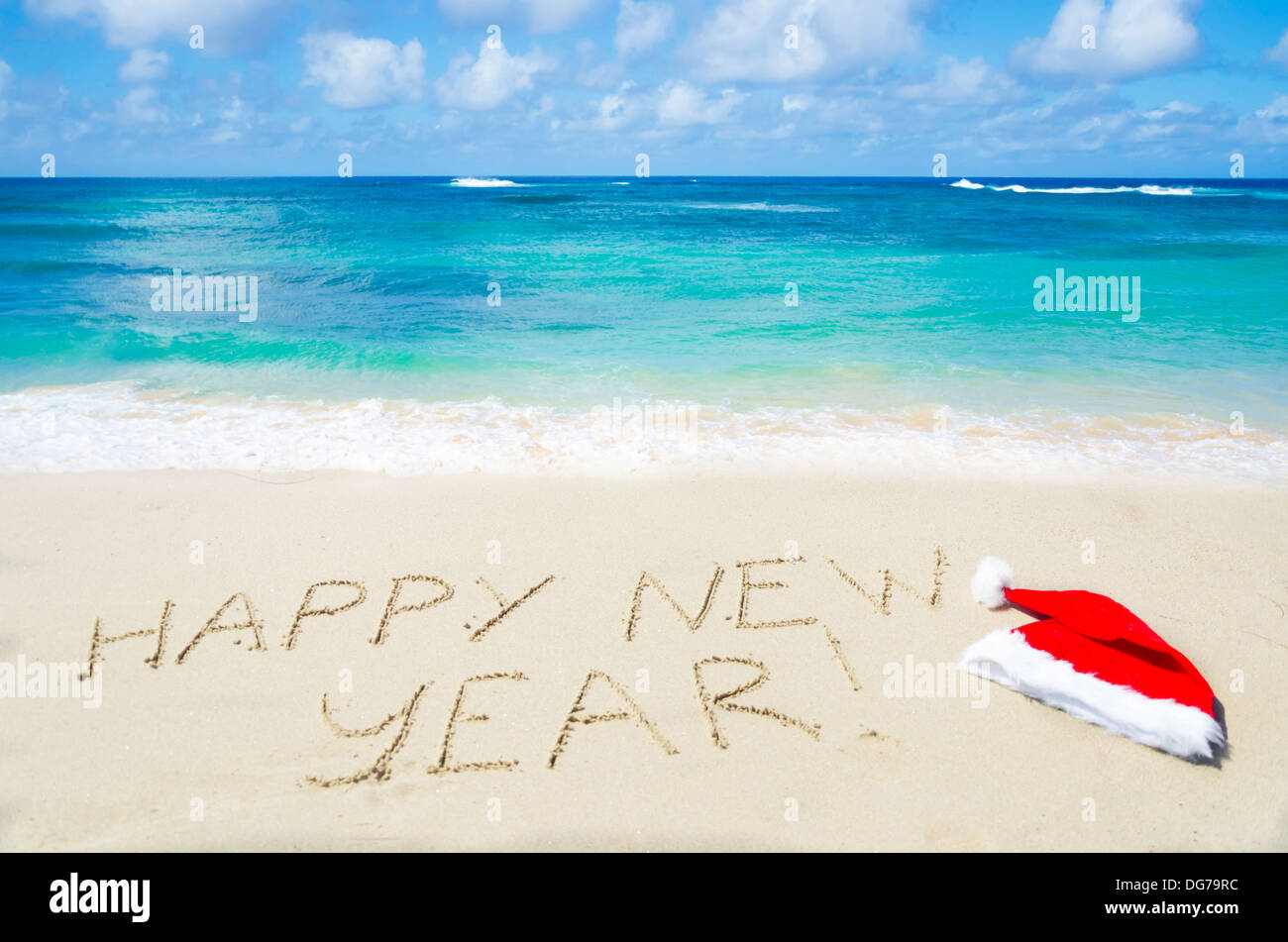 Panneau 'Bonne année !' avec chapeau de Noël sur la plage de sable b- cy le oceanoncept Banque D'Images