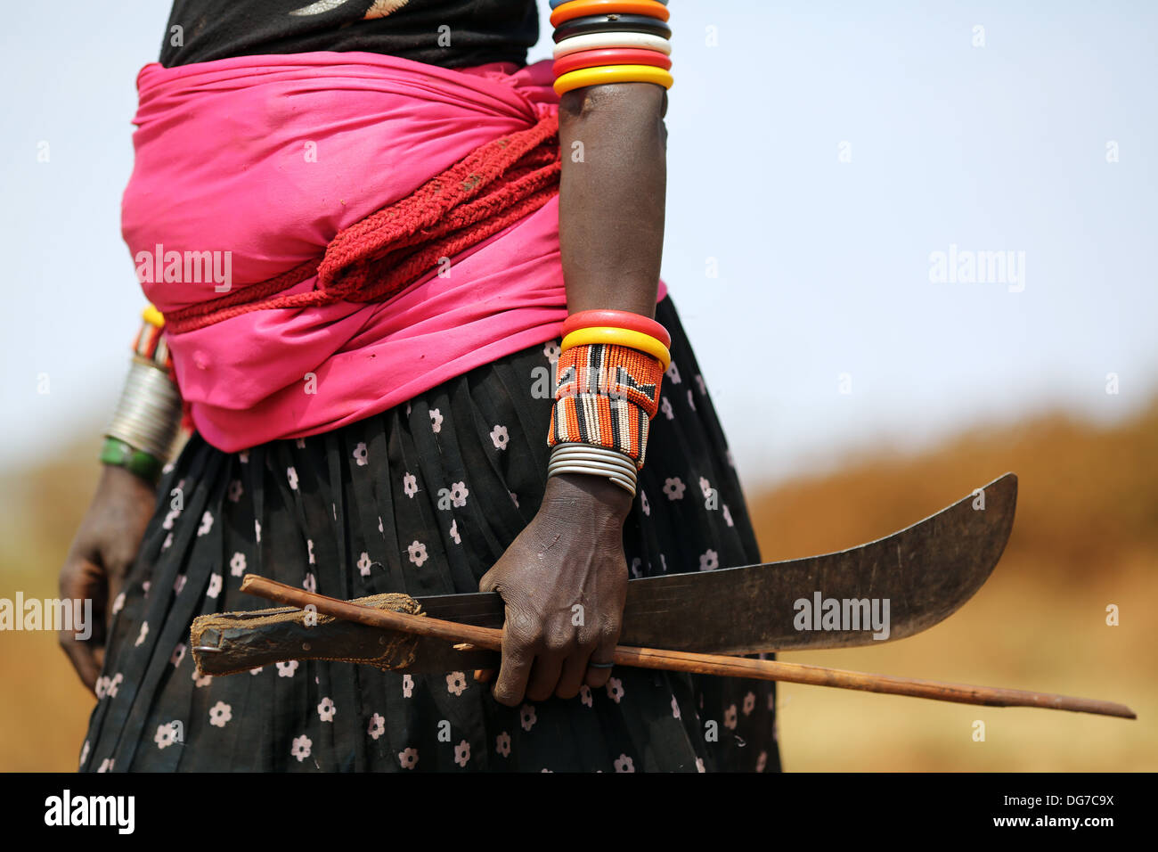 Une femme enceinte femme Rendille holding sa machette tout en s'occupant des chèvres, près de Marsabit, Kenya Banque D'Images