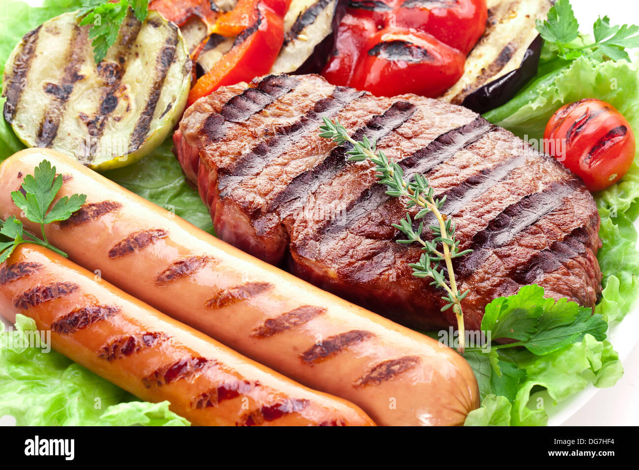 Le steak grillé, saucisses et légumes sur feuilles de laitue. Banque D'Images