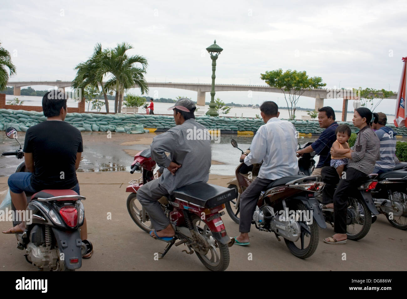 Les gens sur les motos sont à regarder la montée des eaux du Mékong dans la région de Kampong Cham, au Cambodge. Banque D'Images