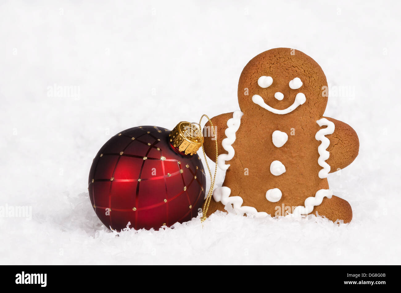 Gingerbread Man cookie et boule de noël ornement rouge sur fond de neige Banque D'Images