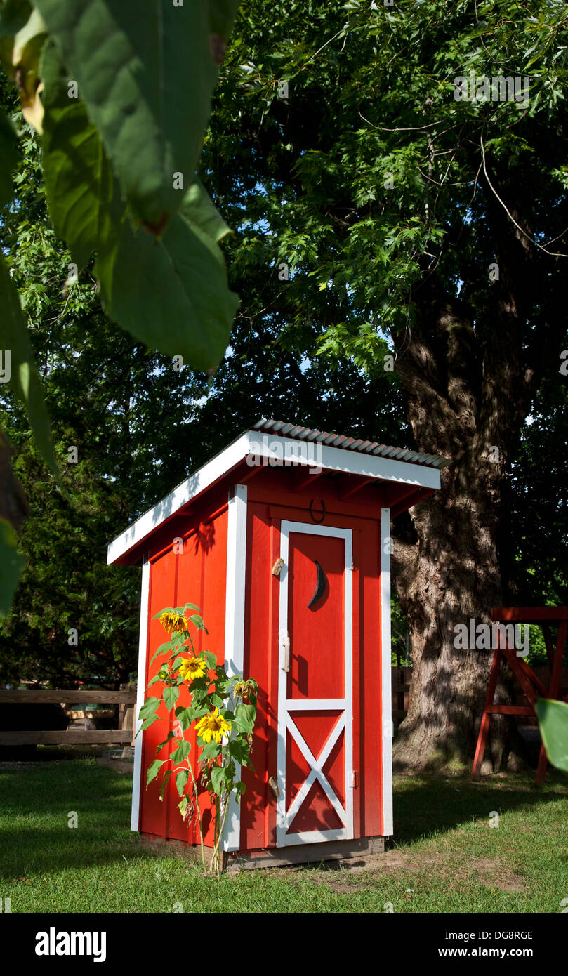 Extérieur coloré rouge vif avec un quart de lune en été avec des tournesols sur une ferme, New Jersey, Etats-Unis, outil de stockage de jardin en bois hangar pt Banque D'Images