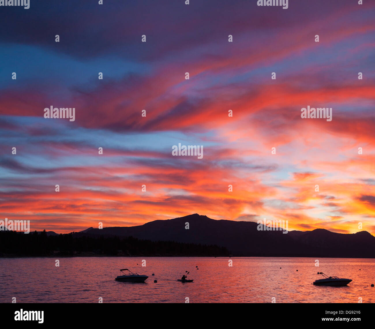 De soleil colorés au lac Tahoe, avec des bateaux, kayakiste et montagnes silhouetté Banque D'Images