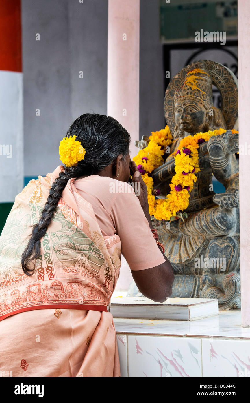 Femme indienne priant à dieu hindou Sarawathi statue. L'Andhra Pradesh, Inde Banque D'Images