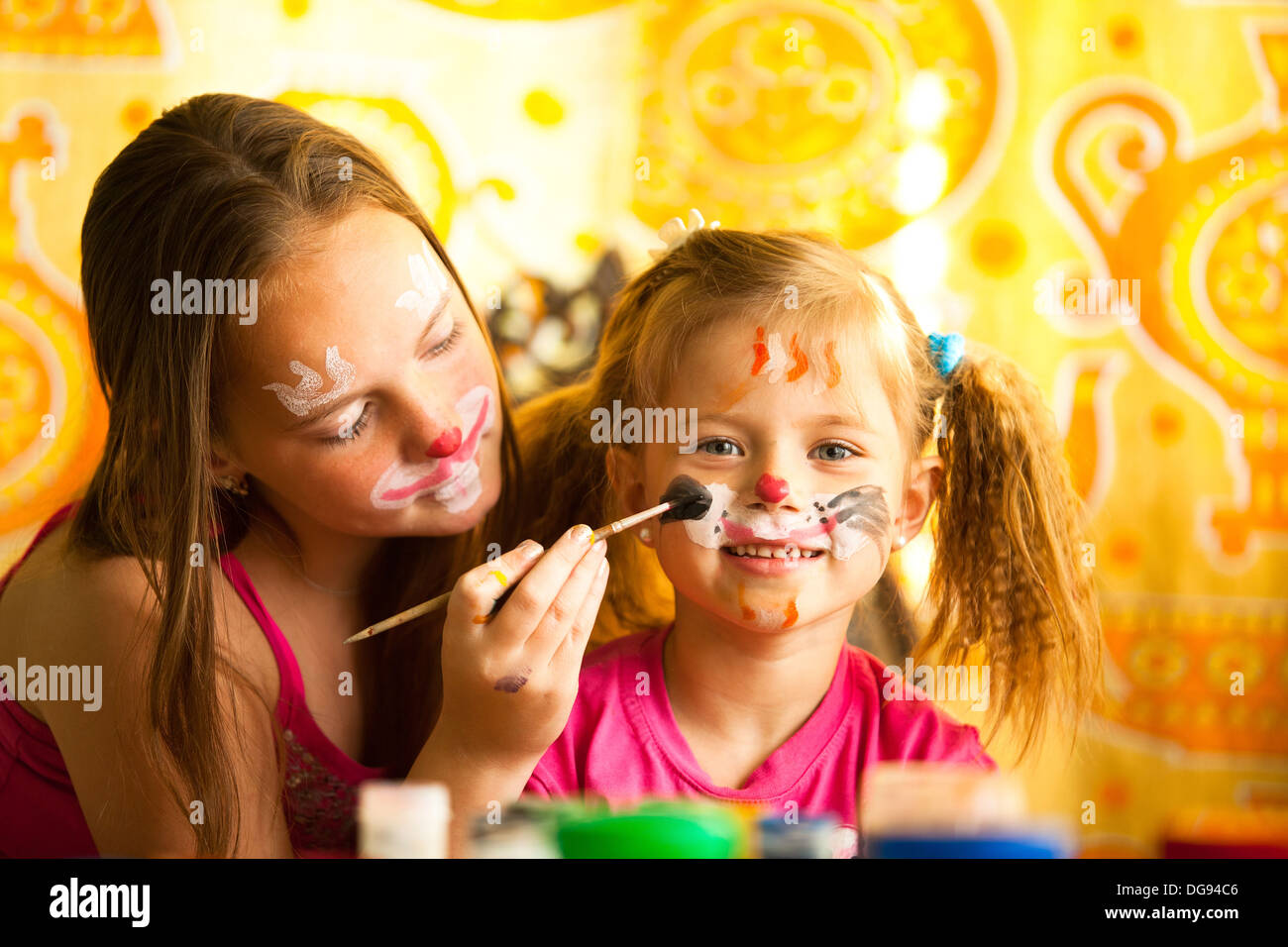 Les jeunes sœurs jouant avec la peinture Banque D'Images