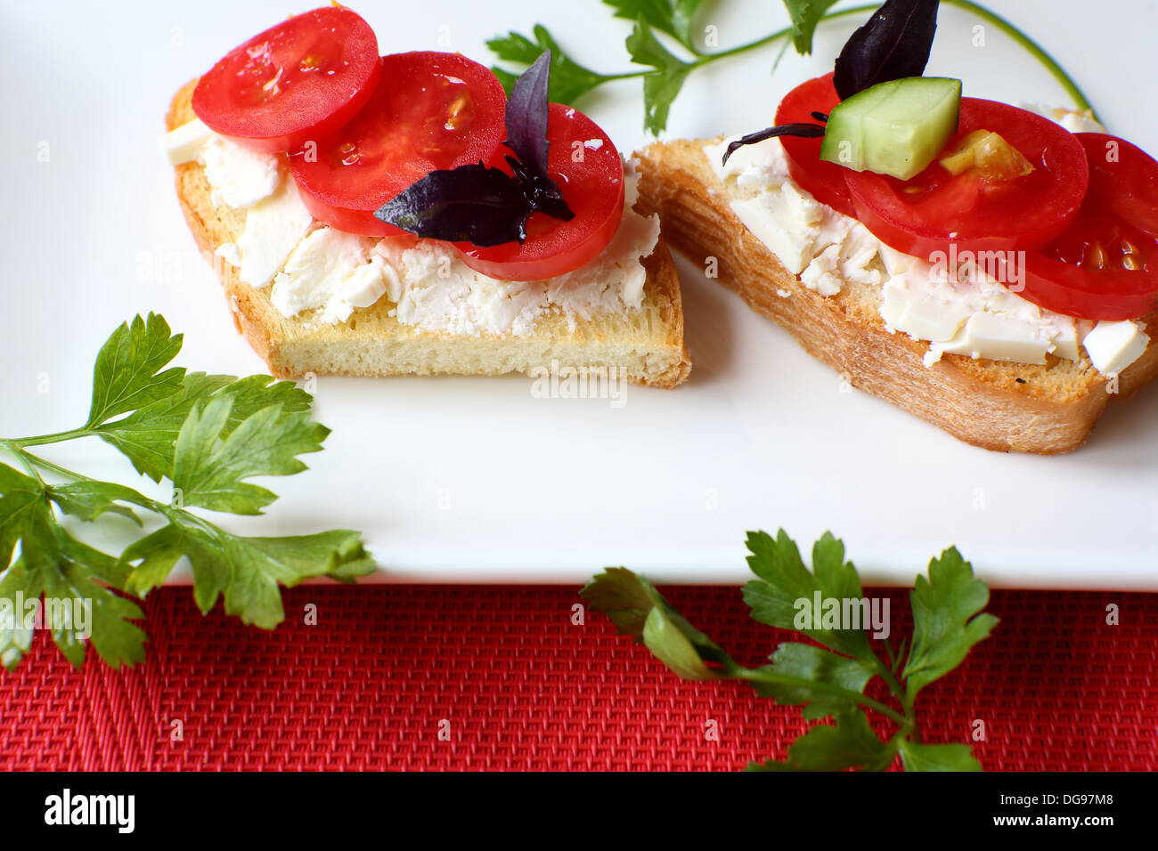 Deux toasts avec du fromage frais et tomates sur une assiette blanche, de l'alimentation Banque D'Images