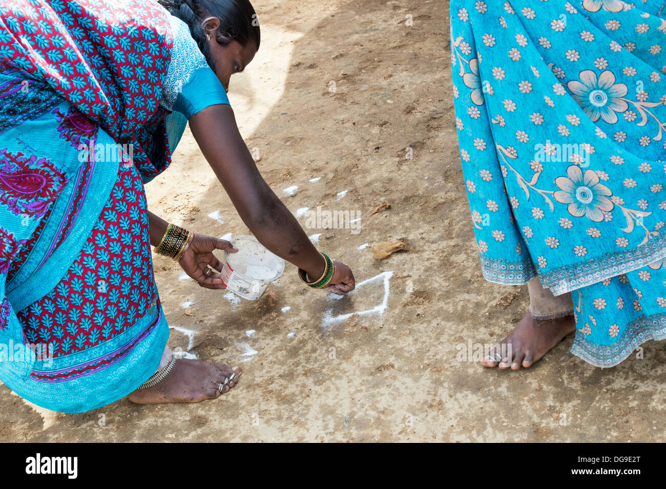 Basse caste indienne faisant le Dasara Rangoli poudre colorée du festival. L'Andhra Pradesh, Inde Banque D'Images