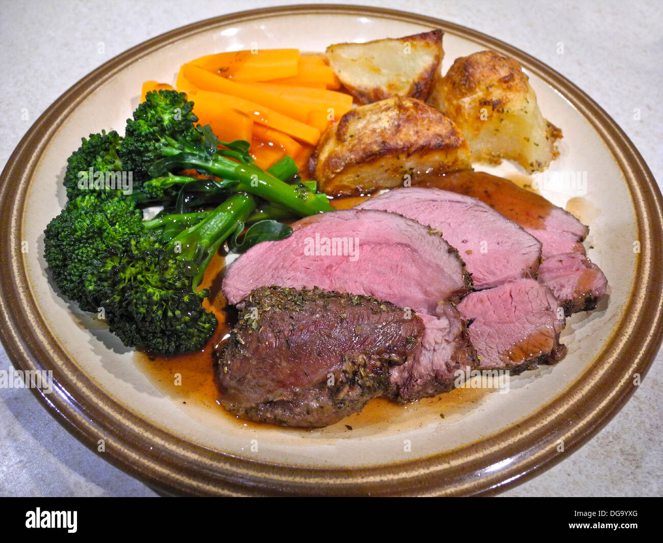 L'agneau rôti de viande avec pommes de terre et carottes brocolli rose rare Banque D'Images