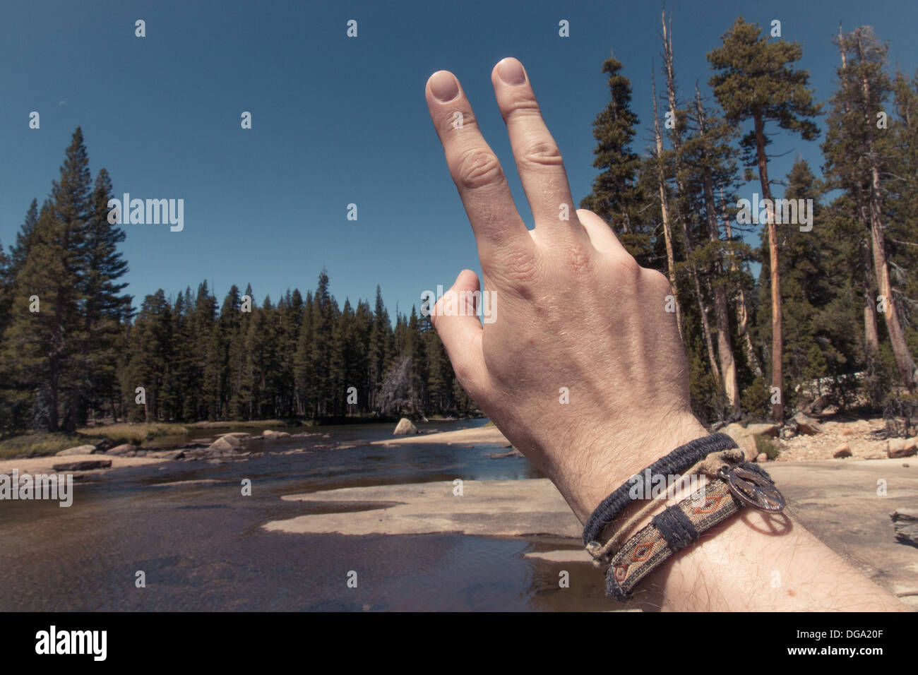 Une main montrant le signe de la paix devant le désert de Yosemite National Park Banque D'Images
