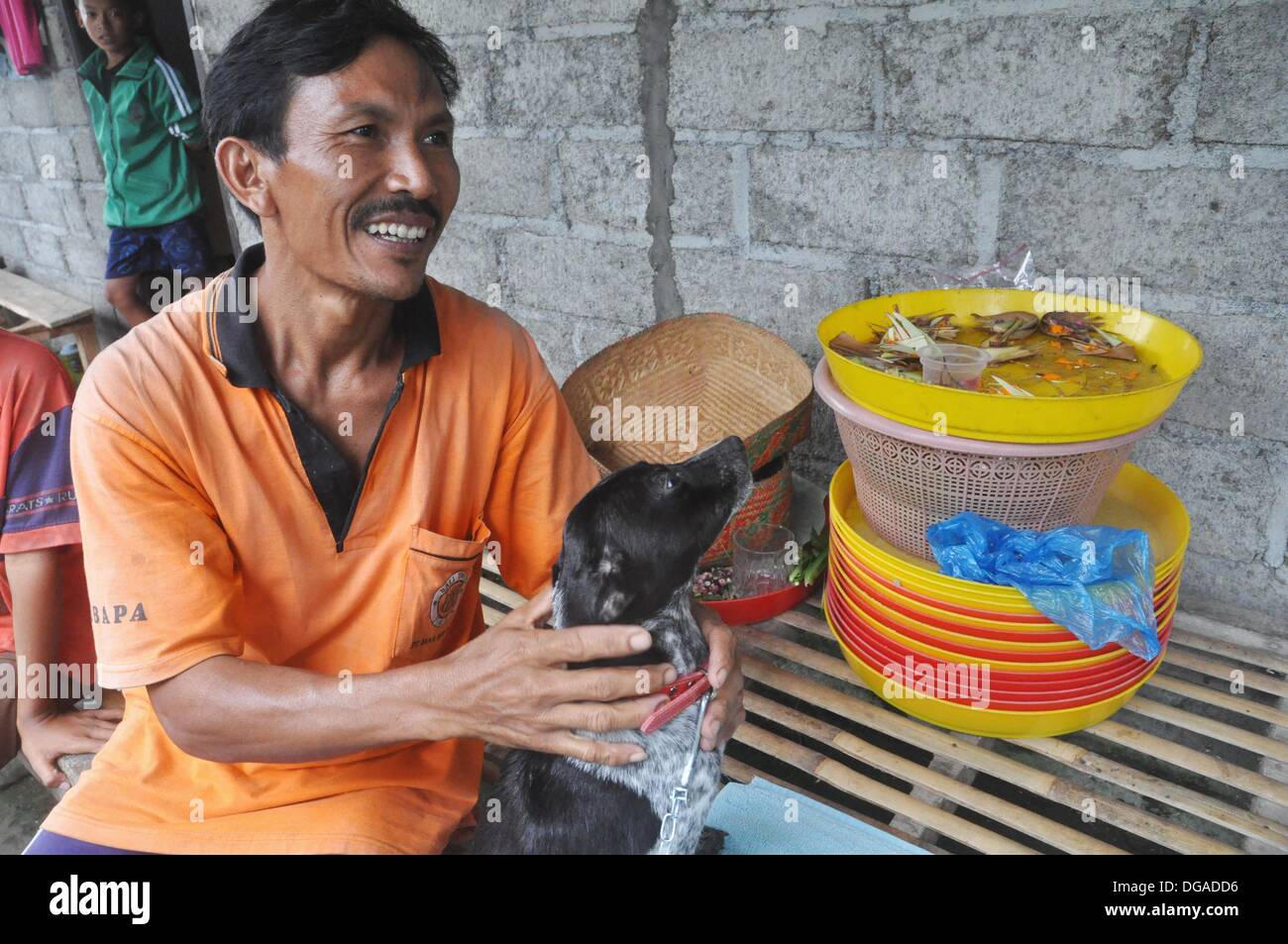 Près de Ubud (Bali, Indonésie) : un fermier souriant après avoir reçu un chiot en cadeau par le B.A.R.C., une association de bénévoles locaux Banque D'Images