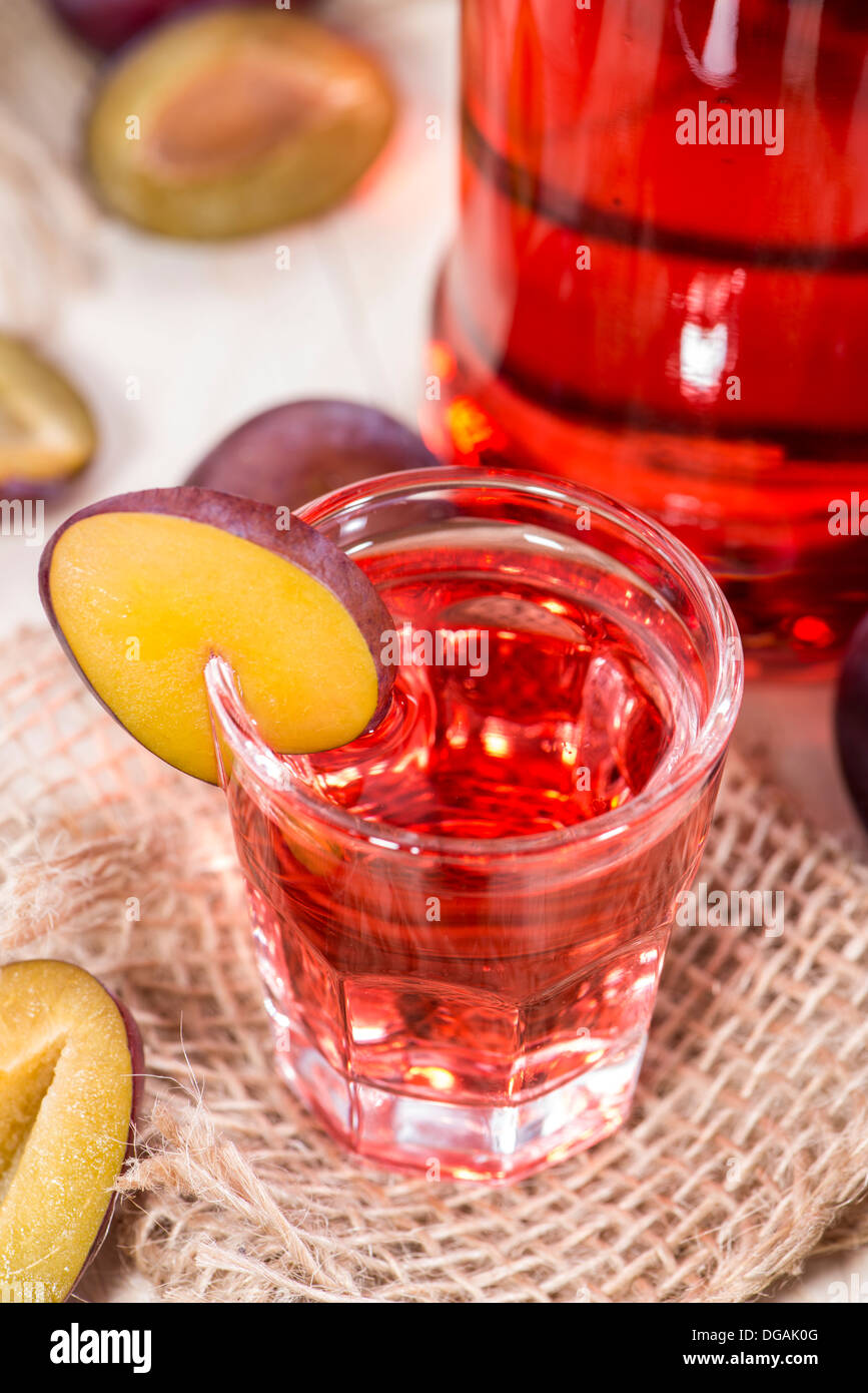 Verre à liqueur de prune sur fond de bois Banque D'Images