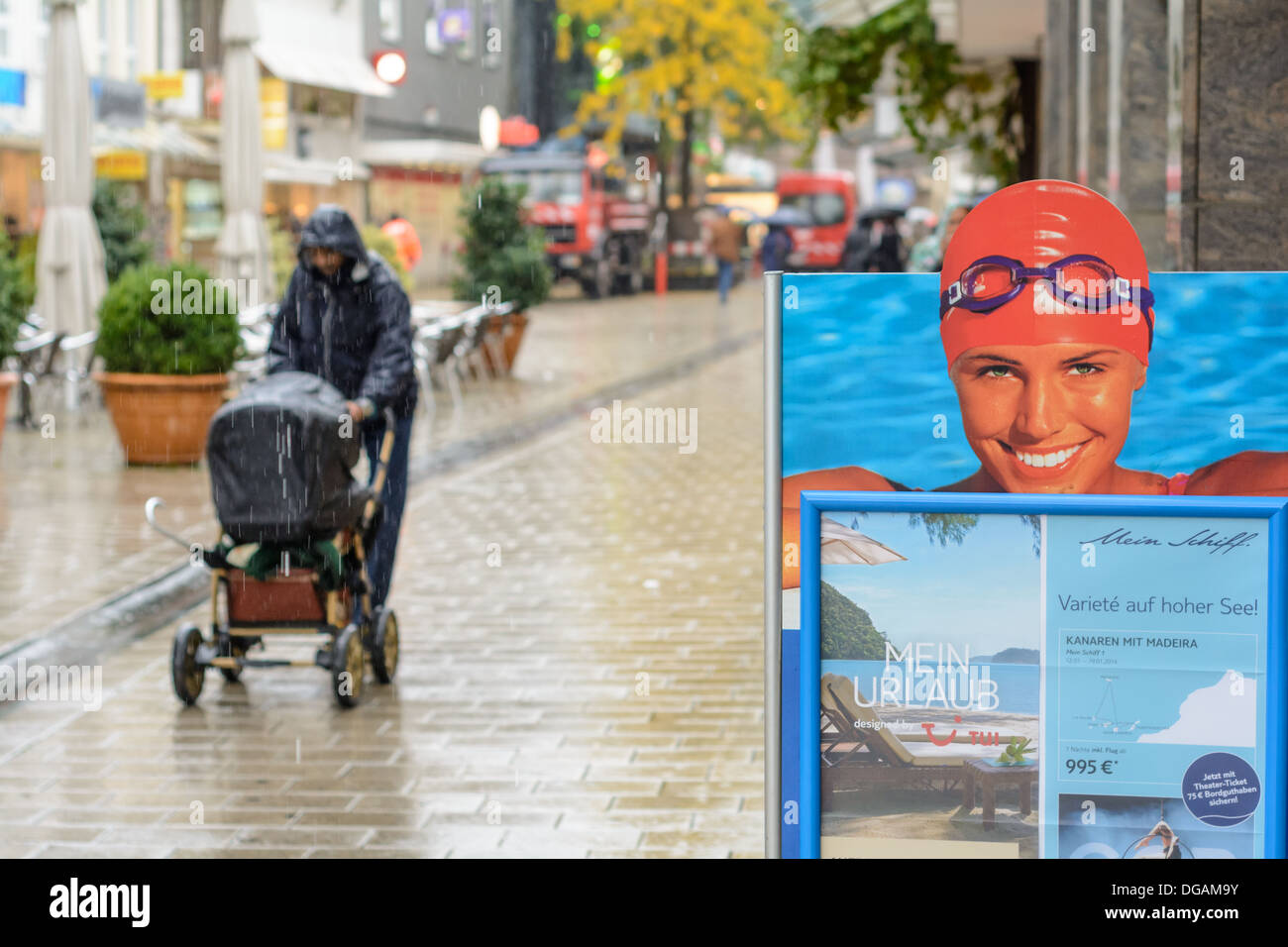 Affiche publicitaire montre jolie femme avec bonnet de bain et des lunettes  de natation et le père avec bébé buggy balade au centre-ville, dans la  pluie Photo Stock - Alamy