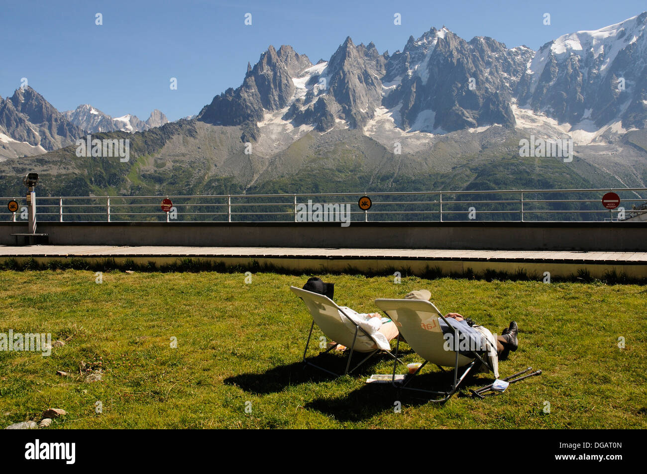 Un couple au soleil dans des chaises longues à Planpraz, dans les Alpes Françaises Banque D'Images
