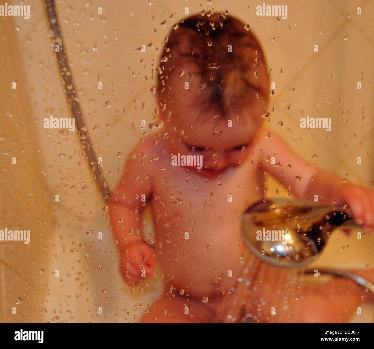 Un petit garçon dans une douche Banque D'Images