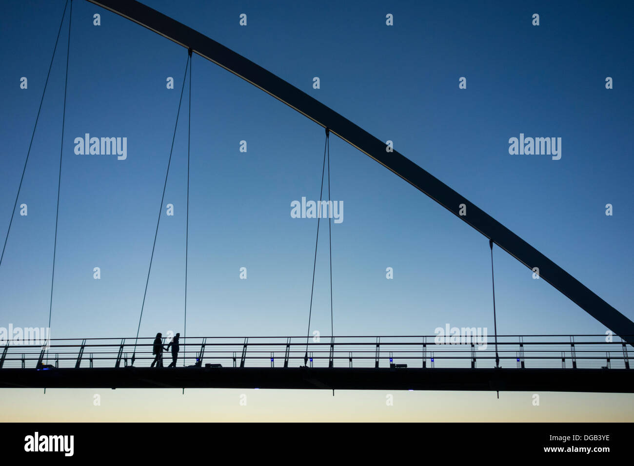 Stockton on Tees, UK. 17 Oct, 2013. Couple holding hands on l'Infini pont sur la Rivière Tees au coucher du soleil sur un ciel du soir d'automne. Credit : ALANDAWSONPHOTOGRAPHY/Alamy Live News Banque D'Images
